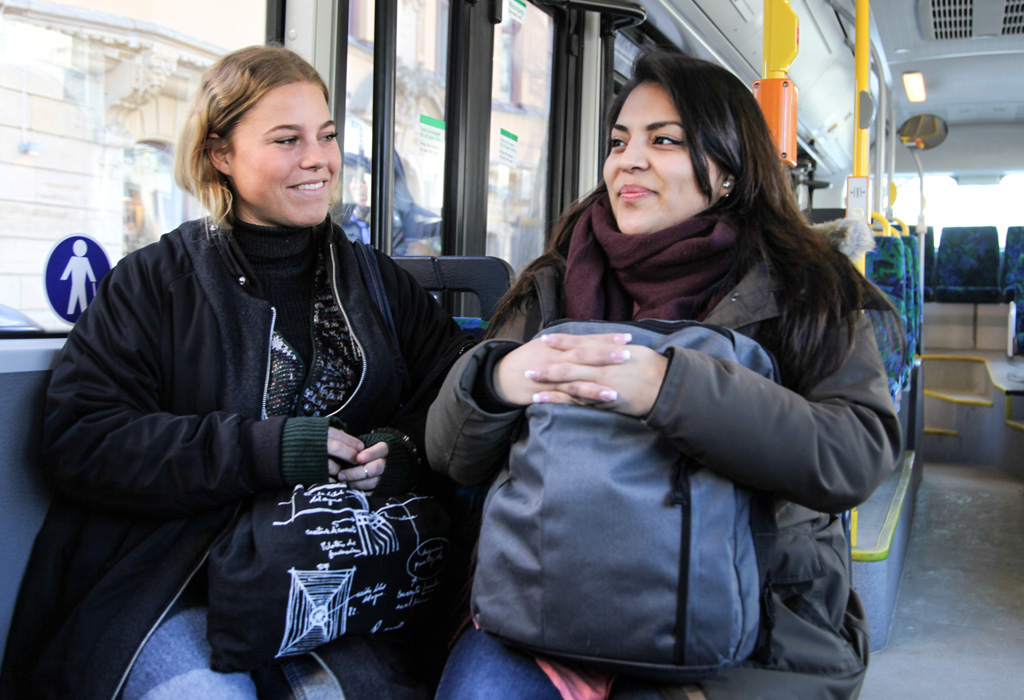 Två kvinnor sitter bredvid varandra i en buss.