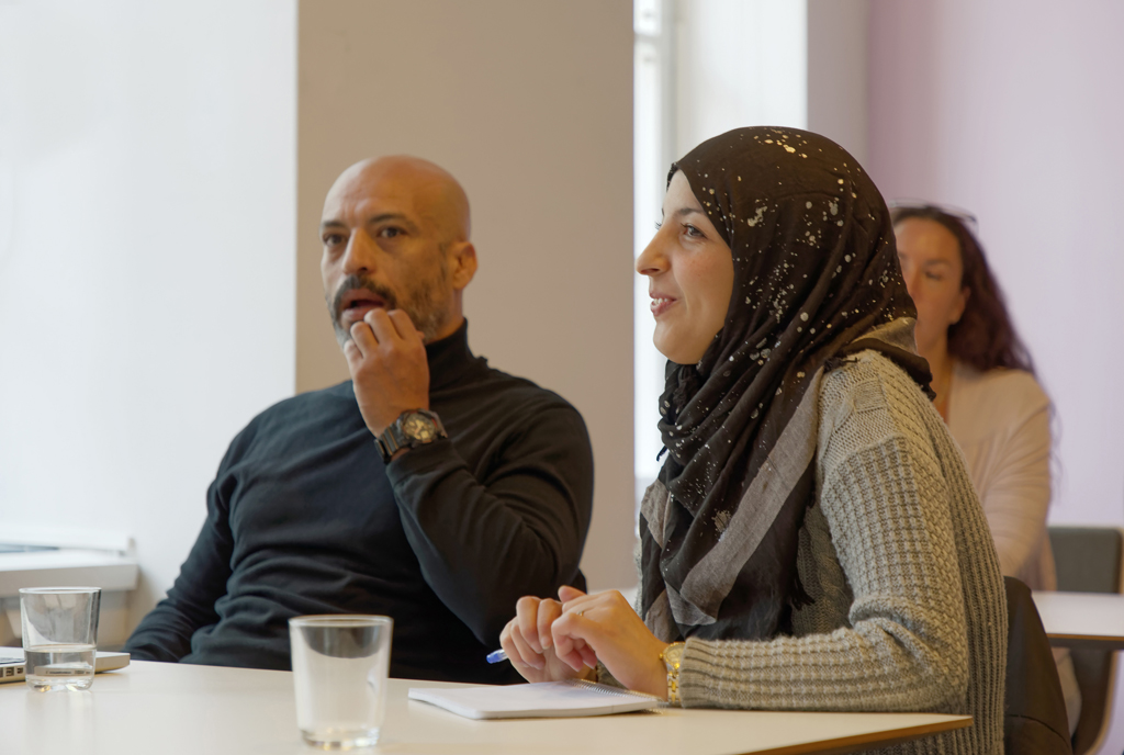 En man och en kvinna sitter vid en bänk och får undervisning.