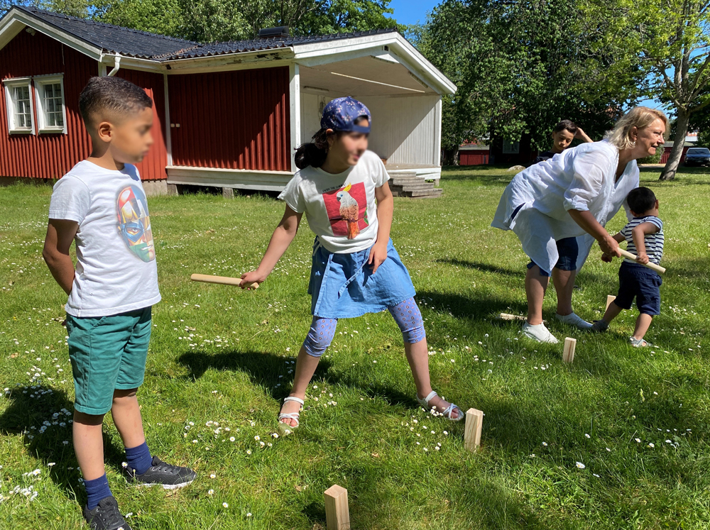 Barn spelar kubb.