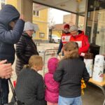 Volontärer från Röda Korset bjuder flyktingar på fika utanför Migrationsverket.