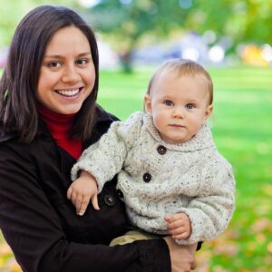 Mamma med ett litet barn i famnen.